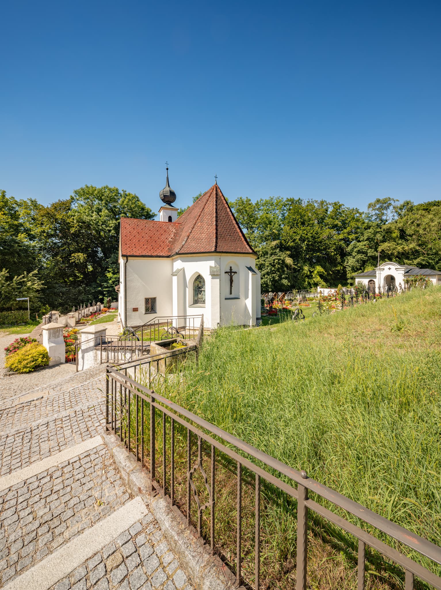 Pfarrkirche Radegundis, Hadermarkt, Braunau am Inn - Pfarrkirche Radegundis in Hadermarkt, St. Radegund, Braunau am Inn, Oberösterreich, Innviertel, Österreich. Kirchengebäude in grüner Landschaft.