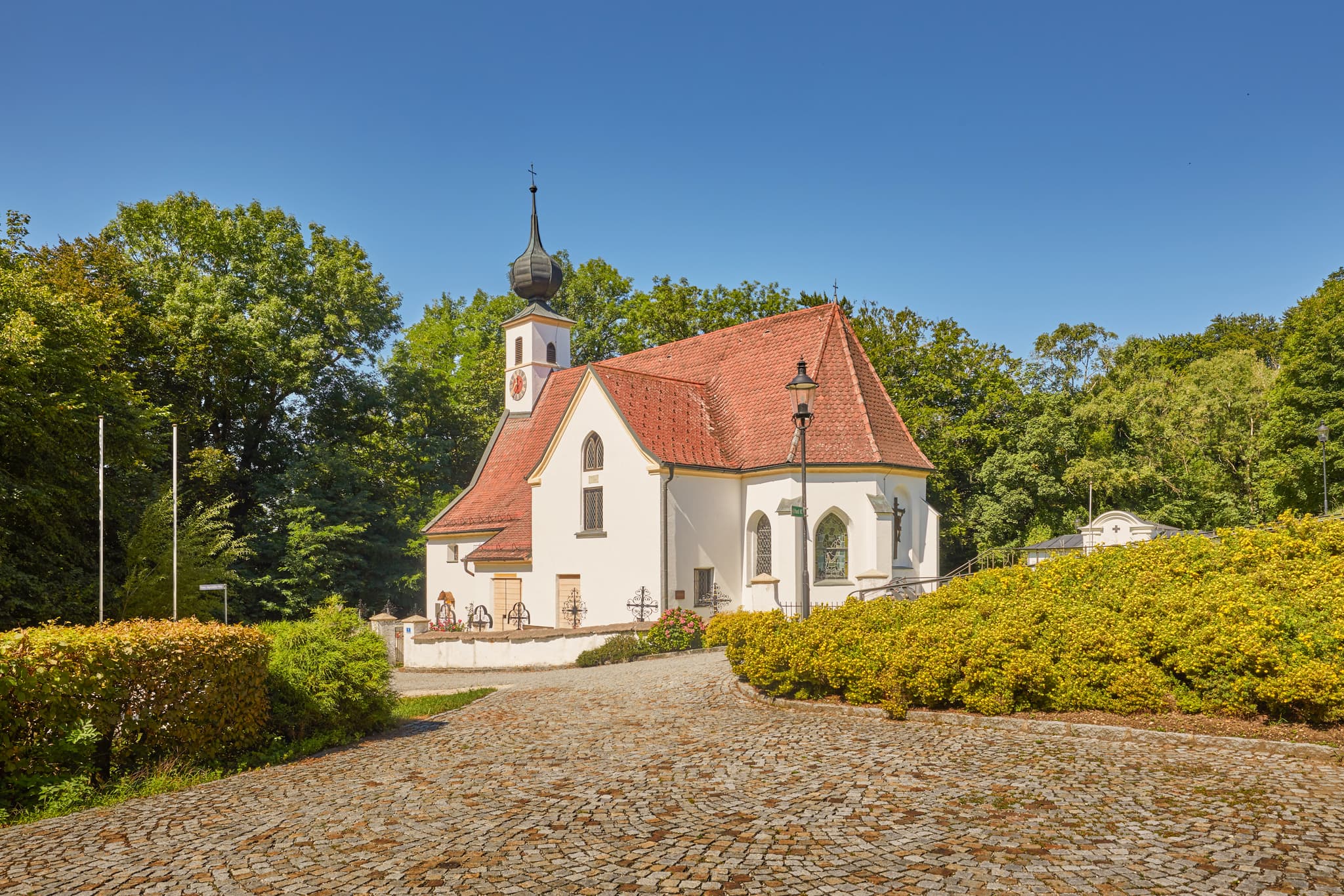 Pfarrkirche Radegundis, Hadermarkt, Braunau am Inn - Pfarrkirche Radegundis in Hadermarkt, St. Radegund, Braunau am Inn, Oberösterreich, Innviertel, Österreich. Kirchengebäude in grüner Landschaft.