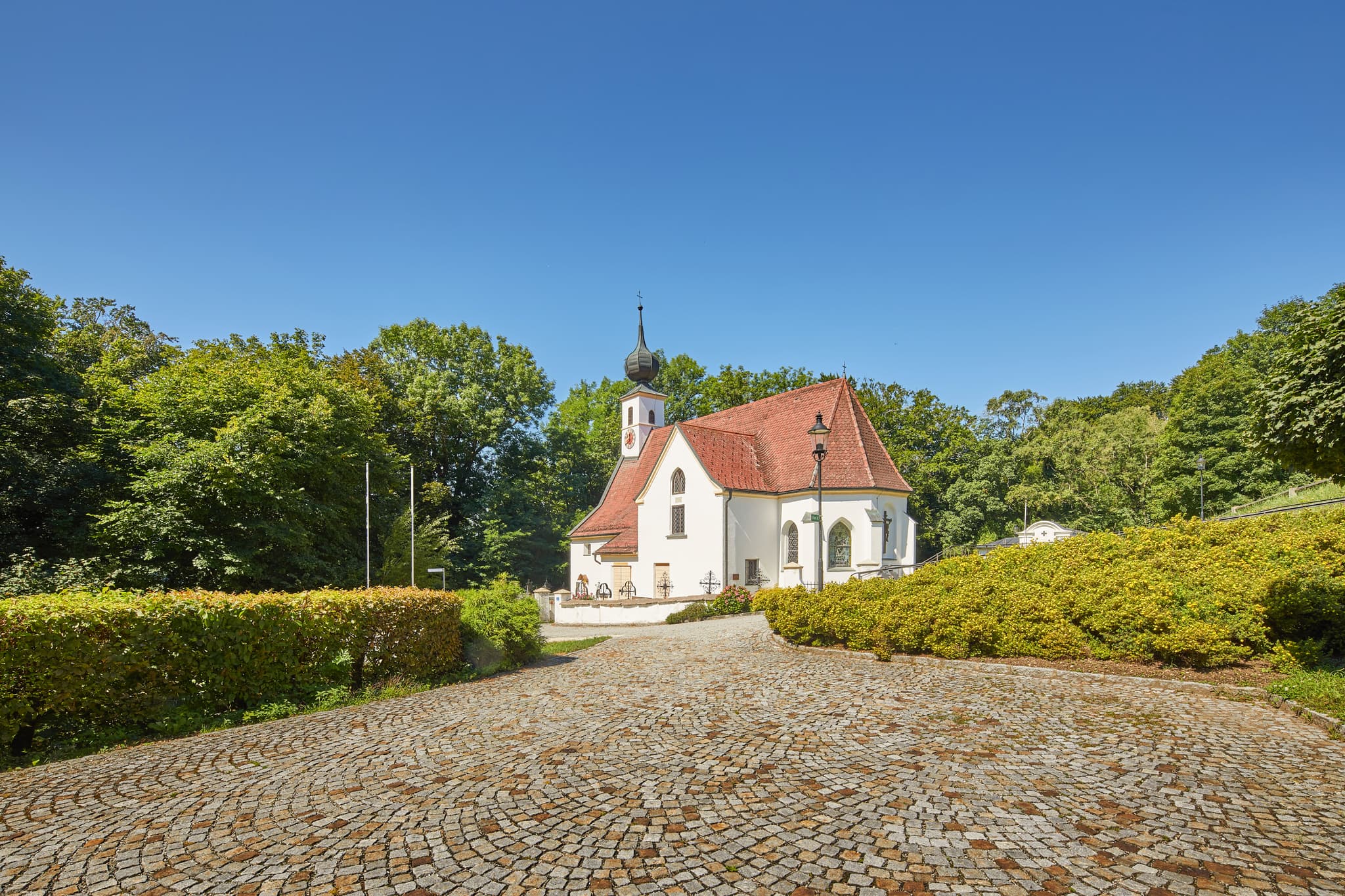 Pfarrkirche Radegundis, Hadermartk, Braunau am Inn - Pfarrkirche Radegundis in Hadermarkt, St. Radegund, Braunau am Inn, Oberösterreich, Innviertel, Österreich. Kirchengebäude in grüner Landschaft.