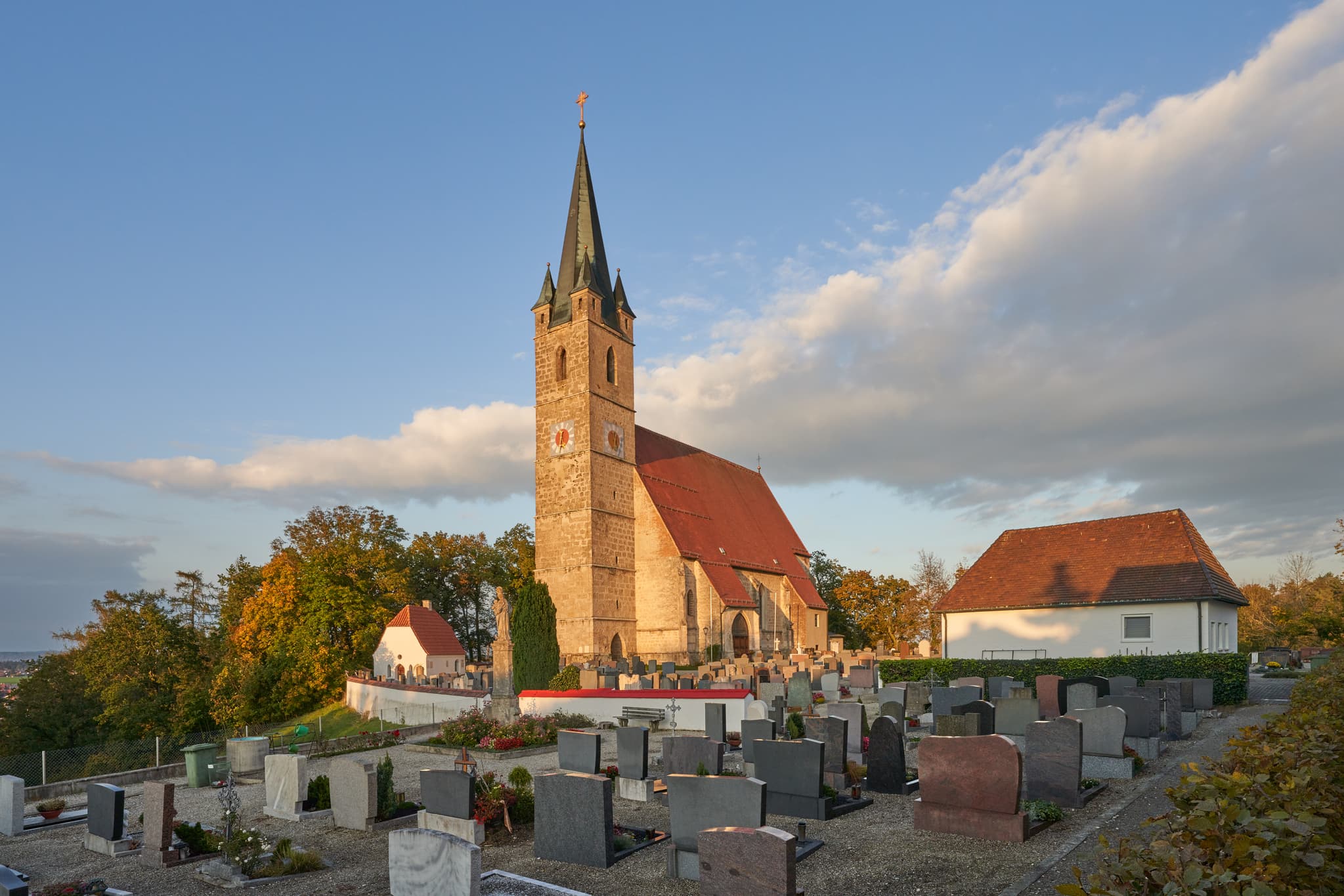 Pfarrkirche St. Rupertus, Burgkirchen am Wald, Oberbayern - Pfarrkirche St. Rupertus, Burgkirchen am Wald, Tüssling, Altötting, Oberbayern. Kirche mit Friedhof auf Anhöhe, beleuchtet von Abendlicht.