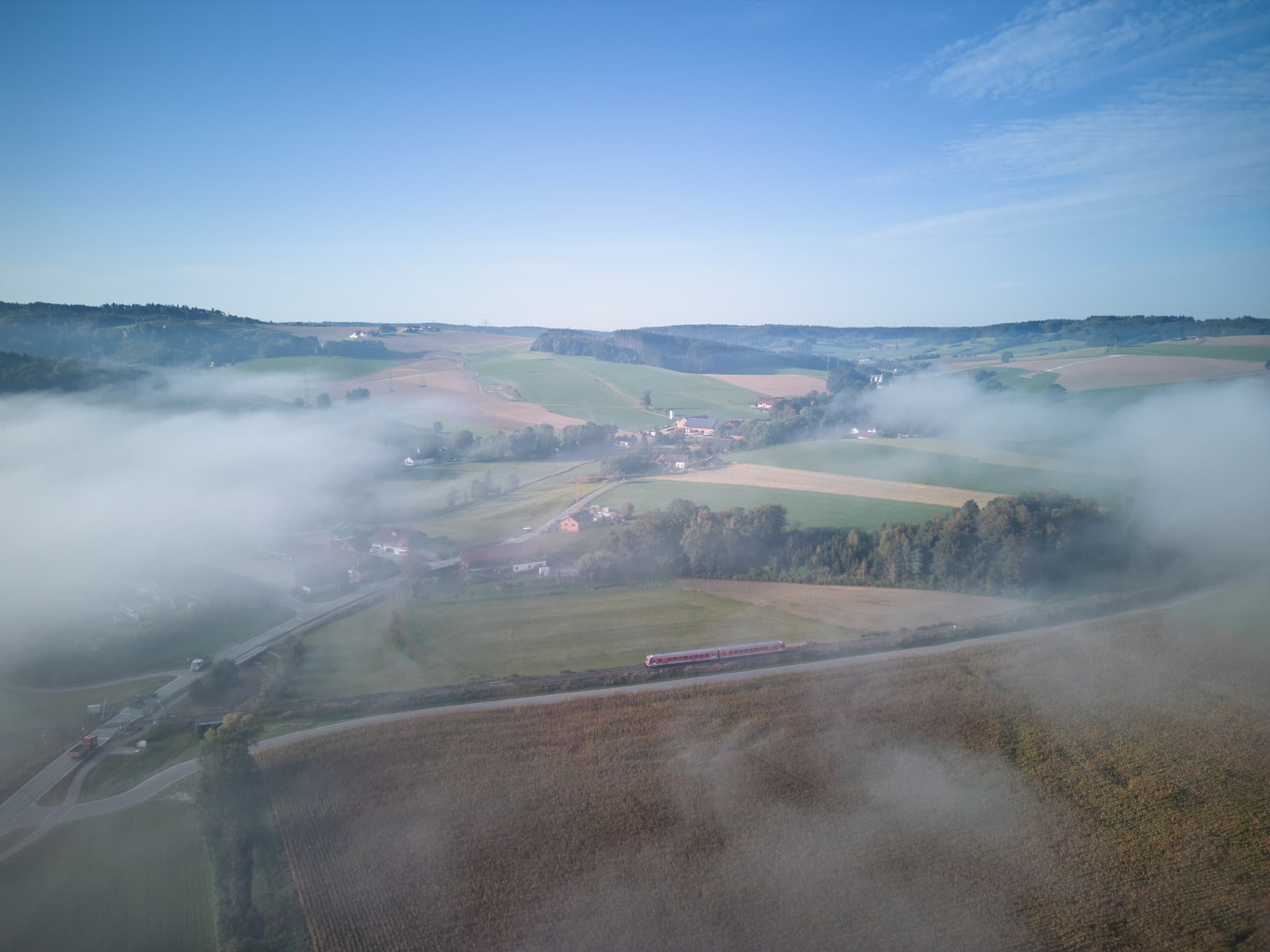 Rottal im Herbst, Bad Birnbach, Niederbayern, Bäderdreieck - Blick auf Bad Birnbach im Rottal-Inn, Niederbayern, Deutschland. Nebel bedeckt die Felder und Hügel, ein Zug fährt. Ländliche Idylle im Bäderdreieck.