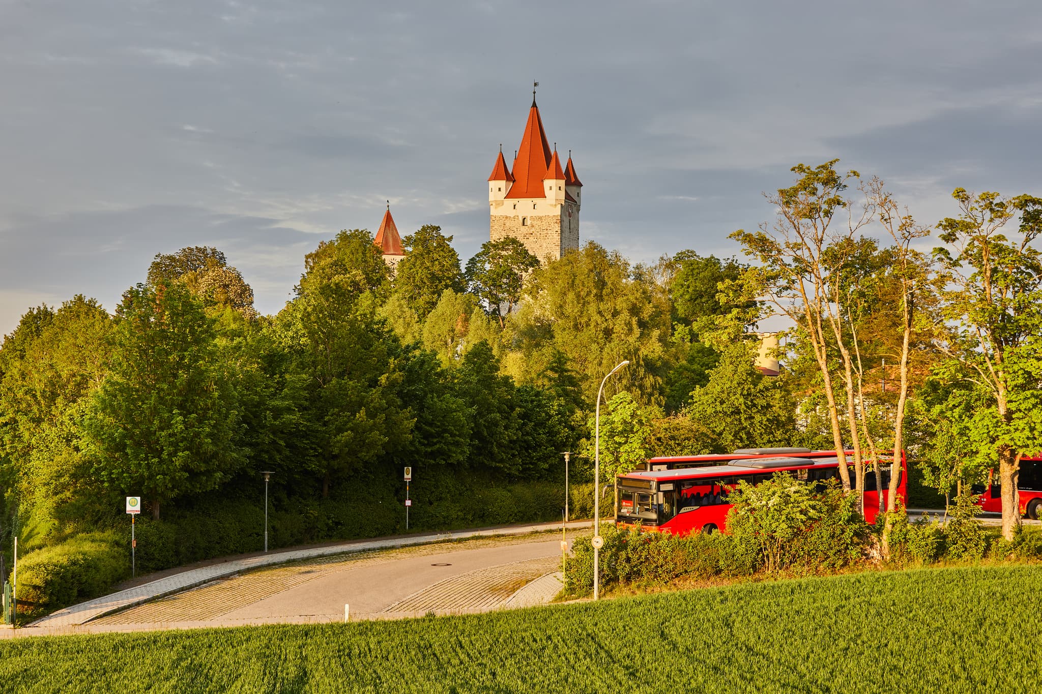 Schlossturm Burg Turm, Haag, Mühldorf am Inn, Oberbayern - Schlossturm in Haag, Landkreis Mühldorf am Inn, Oberbayern. Bild mit Schlossturm, Bäumen, Straße und roten Bussen. Region Inn-Salzach, Deutschland.
