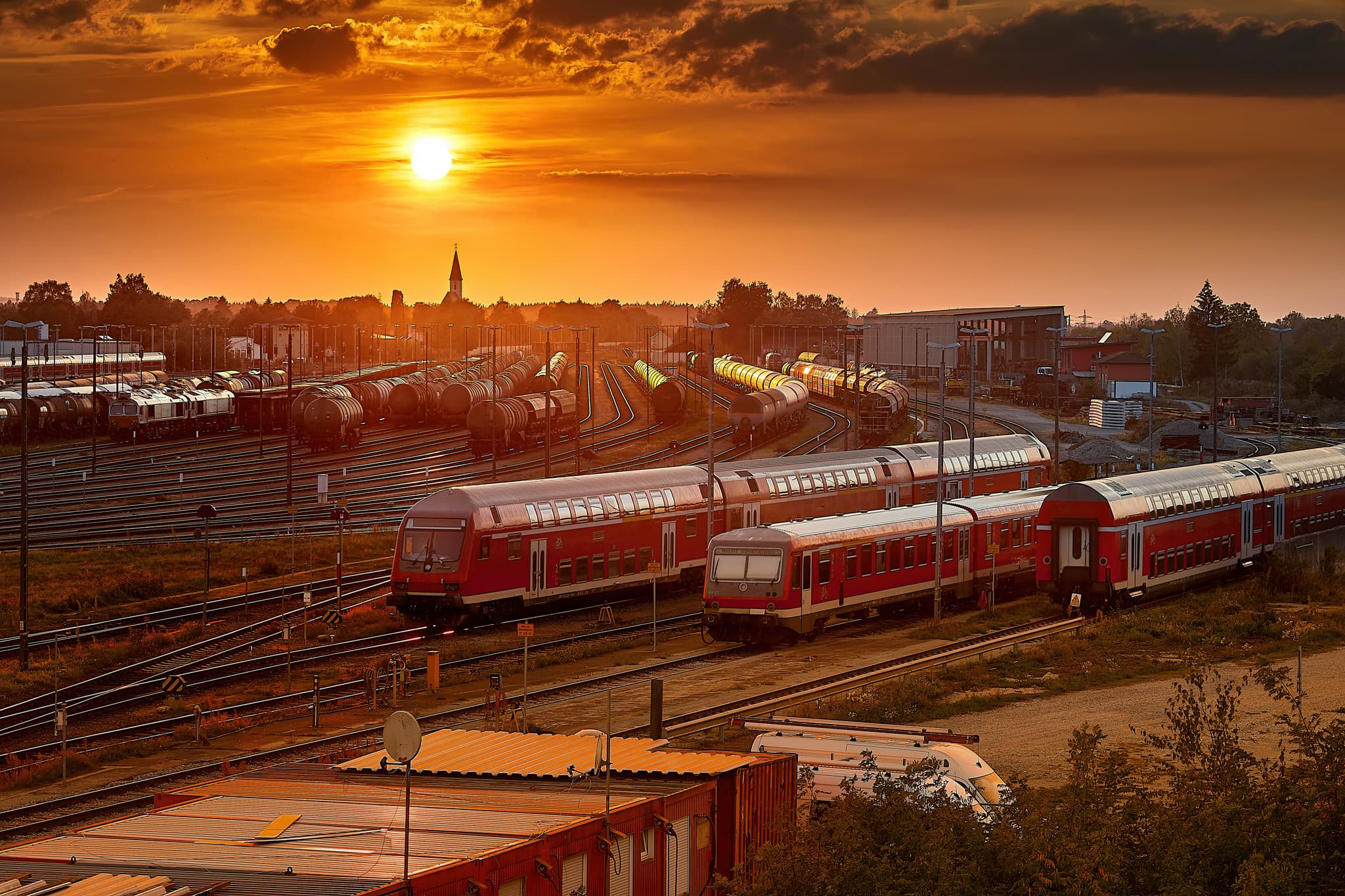 Sonnenuntergang Bahnhof Mühldorf, Oberbayern, Inn-Salzach - Sonnenuntergang am Bahnhof Mühldorf am Inn, Oberbayern. Züge auf den Gleisen des Bahnhofs. Die Szenerie der Region Inn-Salzach fängt die Abendstimmung ein.