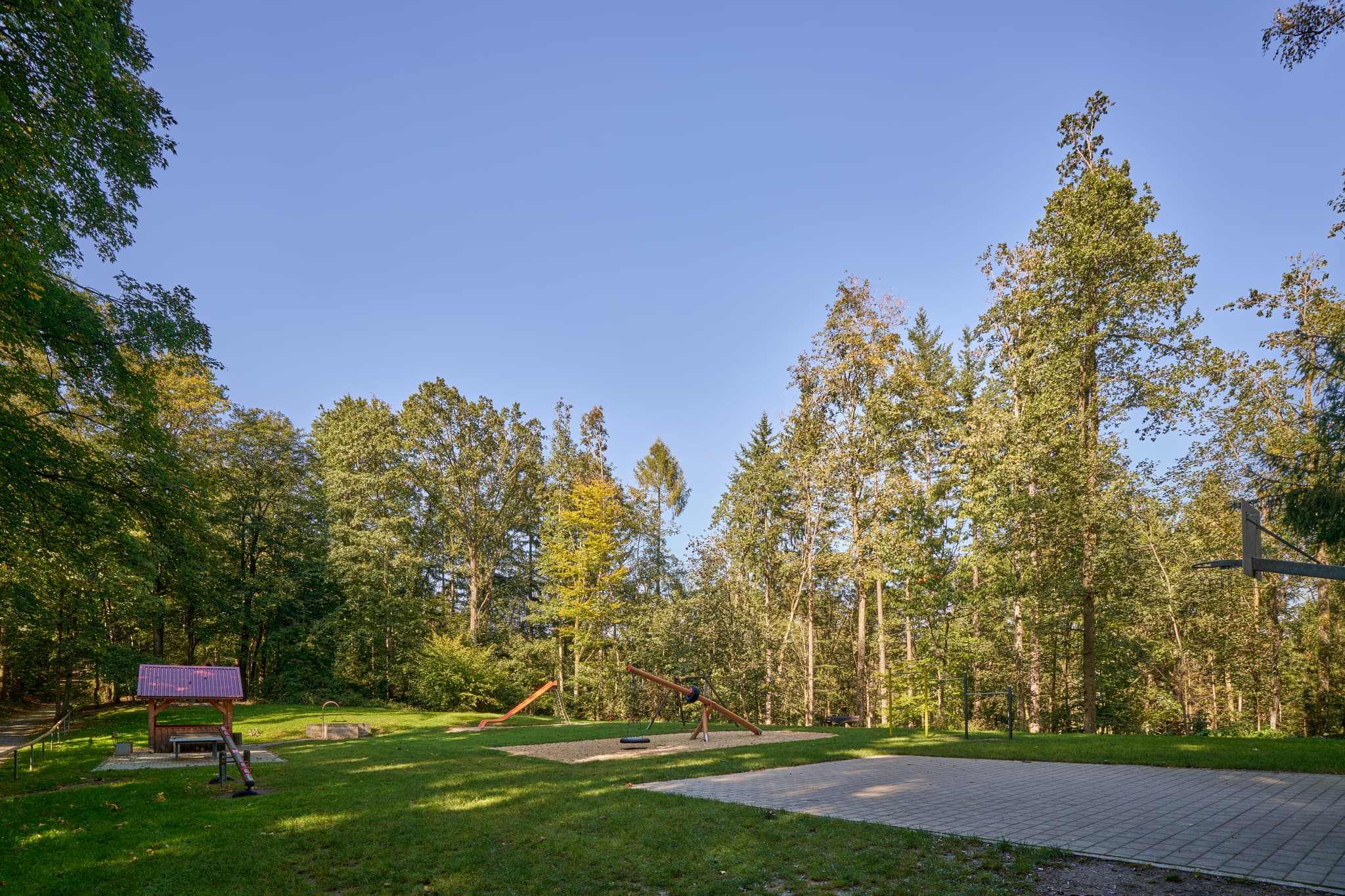 Spielplatz an der Waldwunderwelt, Bad Griesbach, Passau - Spielplatz in Bad Griesbach, Passau, Niederbayern. Blick durch Holzkonstruktion auf Grünfläche mit Spielgeräten. Niederbayern, Bayern, Deutschland.