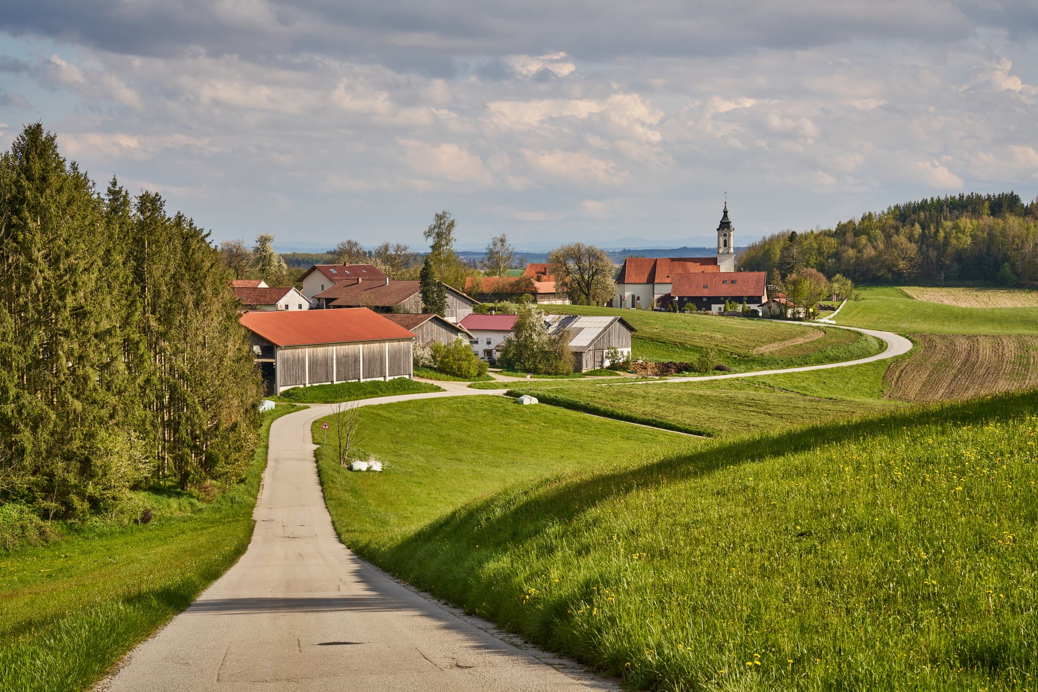 St. Wolfgang im Frühling, Bad Griebsach, Niederbayern - Malerisches Frühlingsbild von St. Wolfgang, Bad Griebsach, Landkreis Passau, Niederbayern, Deutschland. Zeigt Kirche, grüne Hügel, Weg im Bayerischen Wald.