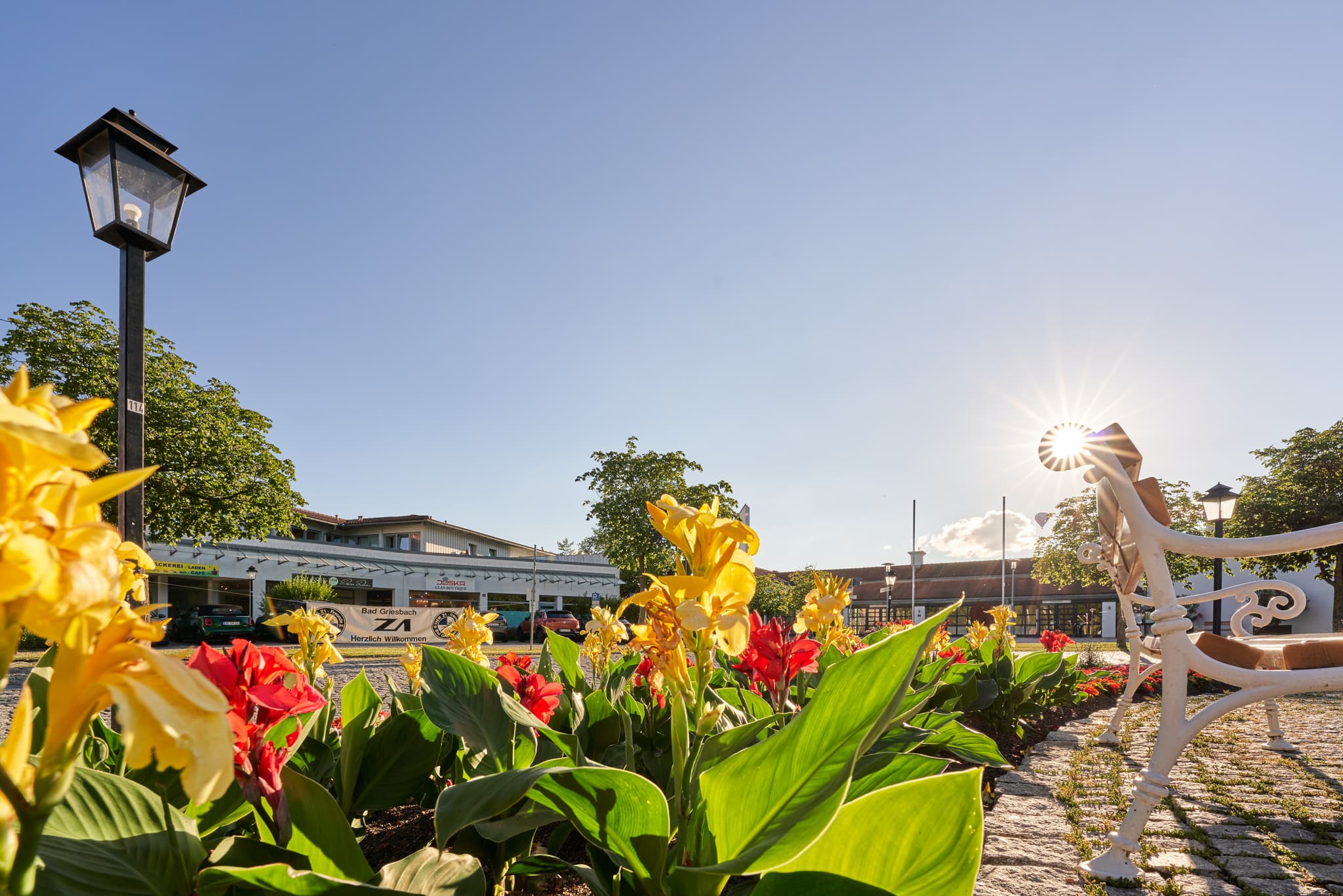 Therme Kreisverkehr Brunnen an der Kurallee, Passau - Blumenbeete am Kreisverkehr Brunnen Kurallee, Bad Griesbach, Passau, Niederbayern, Deutschland. Parkbank und Laterne zieren diesen Ort im Bayerischen Wald.
