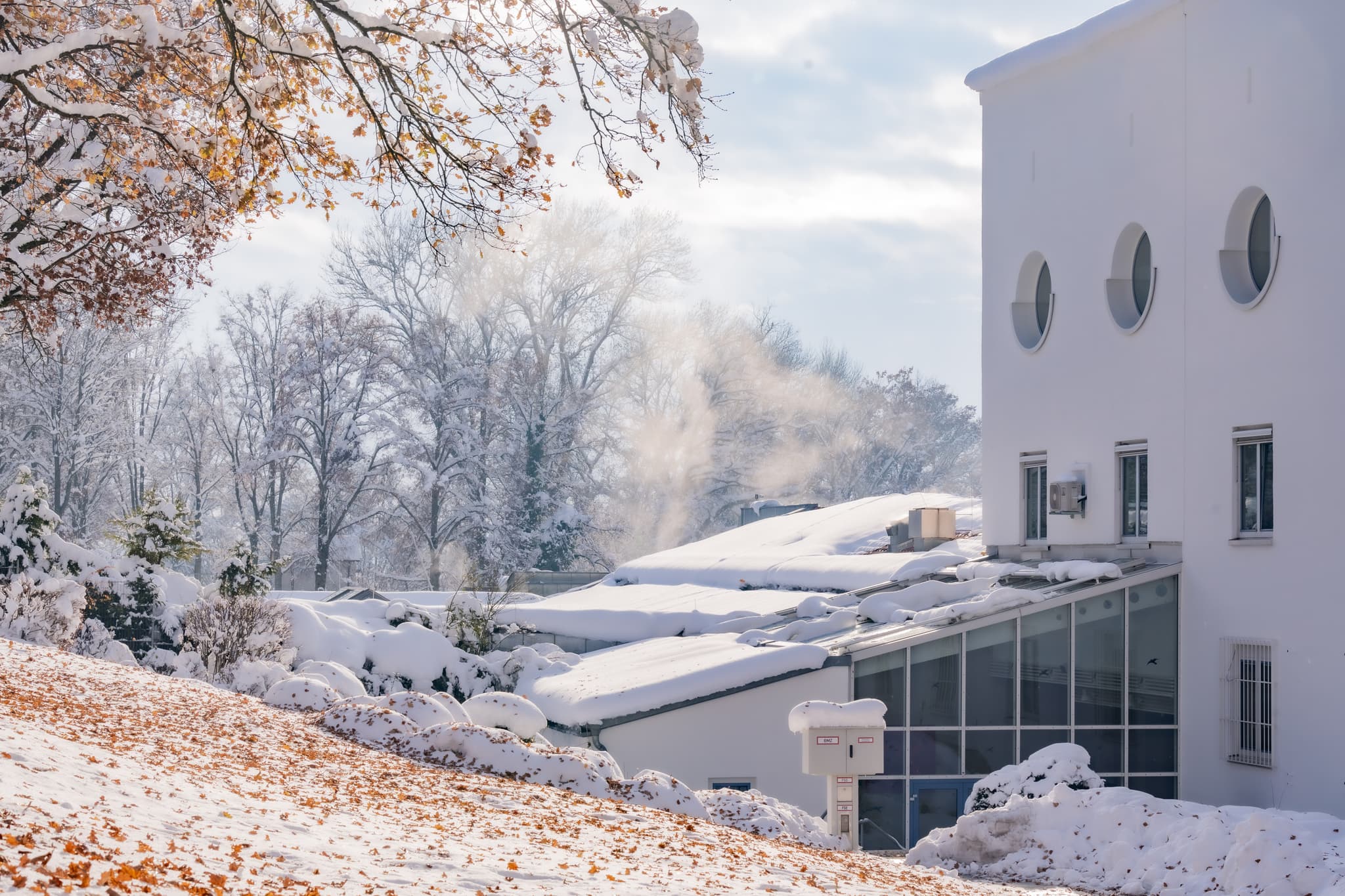 Therme Kurpark Winter, Bad Griesbach, Passau - Winterliche Ansicht der Therme in Bad Griesbach, Passau, Niederbayern. Das Bild zeigt das Außenbecken im Schnee, umgebende Gebäuden und verschneiter Landschaft.
