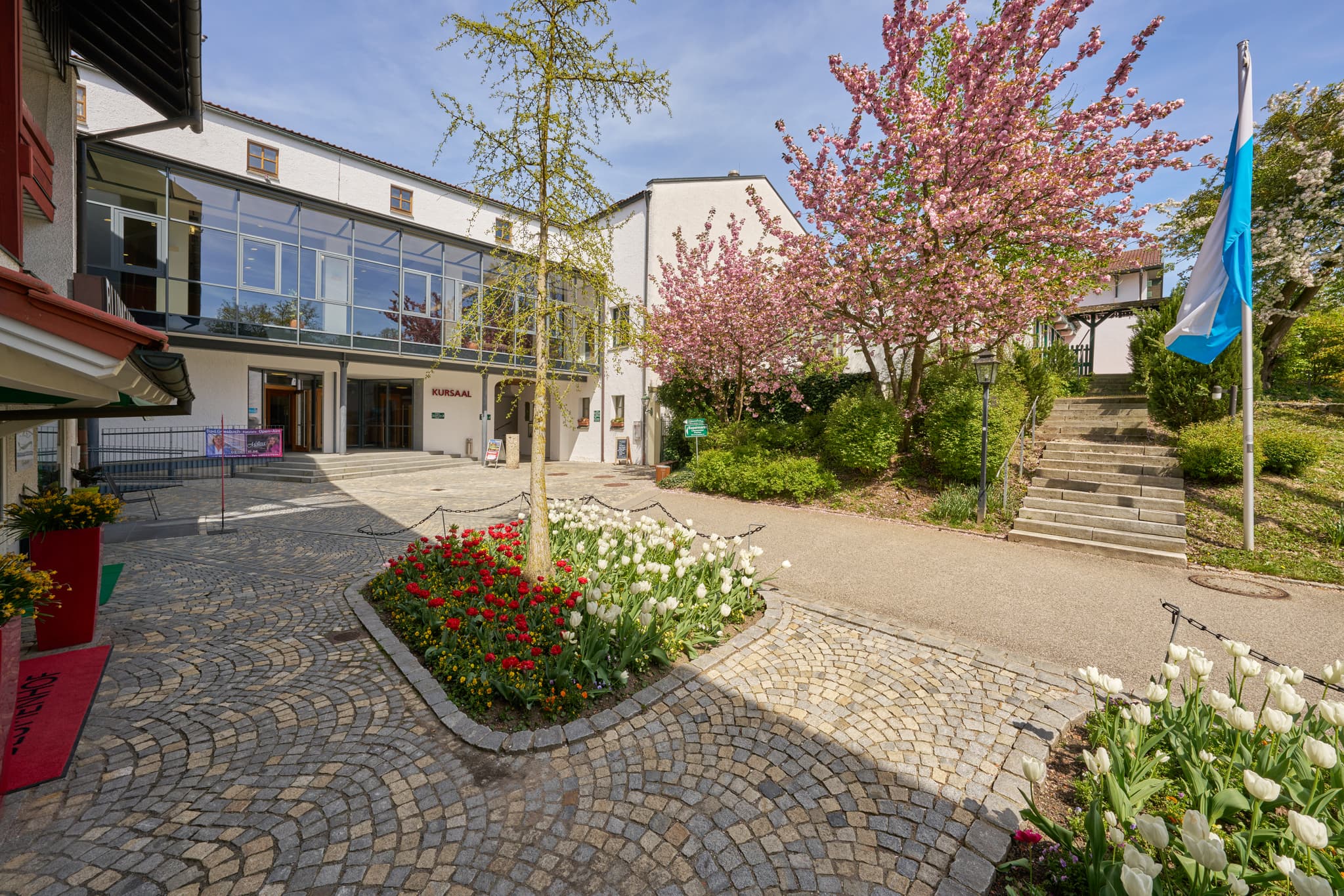 Therme Kursaal Bad Griesbach, Passau, Niederbayern, Rottal - Frühlingsansicht des Kursaals in Bad Griesbach, Landkreis Passau, Niederbayern. Zeigt blühende Bäume, Blumen und den Vorplatz im Rottal, Deutschland.