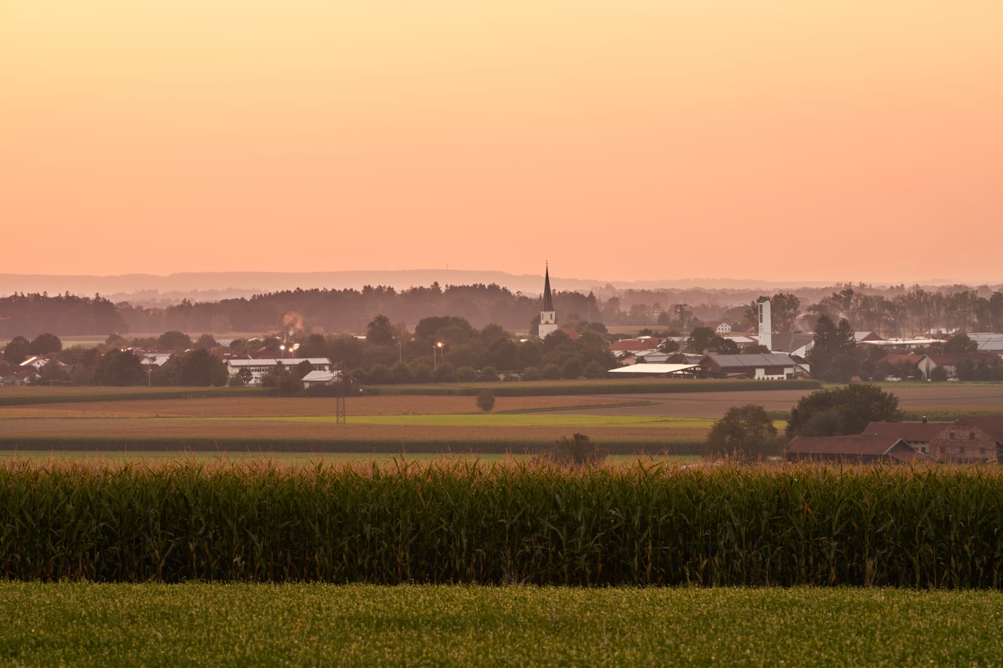 Unterneukirchen, Oberschroffen, Altötting, Oberbayern - Blick von Oberschroffen auf die Landschaft Unterneukirchens im Landkreis Altötting, Oberbayern. Abenddämmerung über Feldern und Dorf in der Inn-Salzach Region.