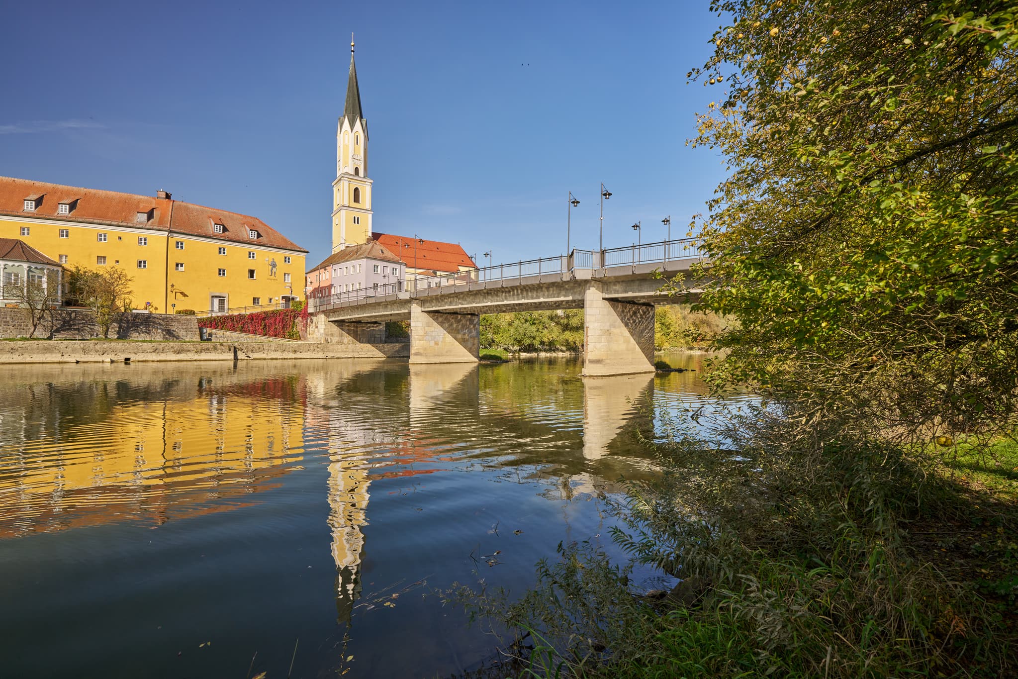 Vils Stadtansicht, Vilshofen, Passau, Niederbayern - Stadtansicht Vilshofen an der Vils, Landkreis Passau, Niederbayern. Historische Gebäude, Kirchturm und Brücke spiegeln sich im Fluss. Donau-Wald, Deutschland.