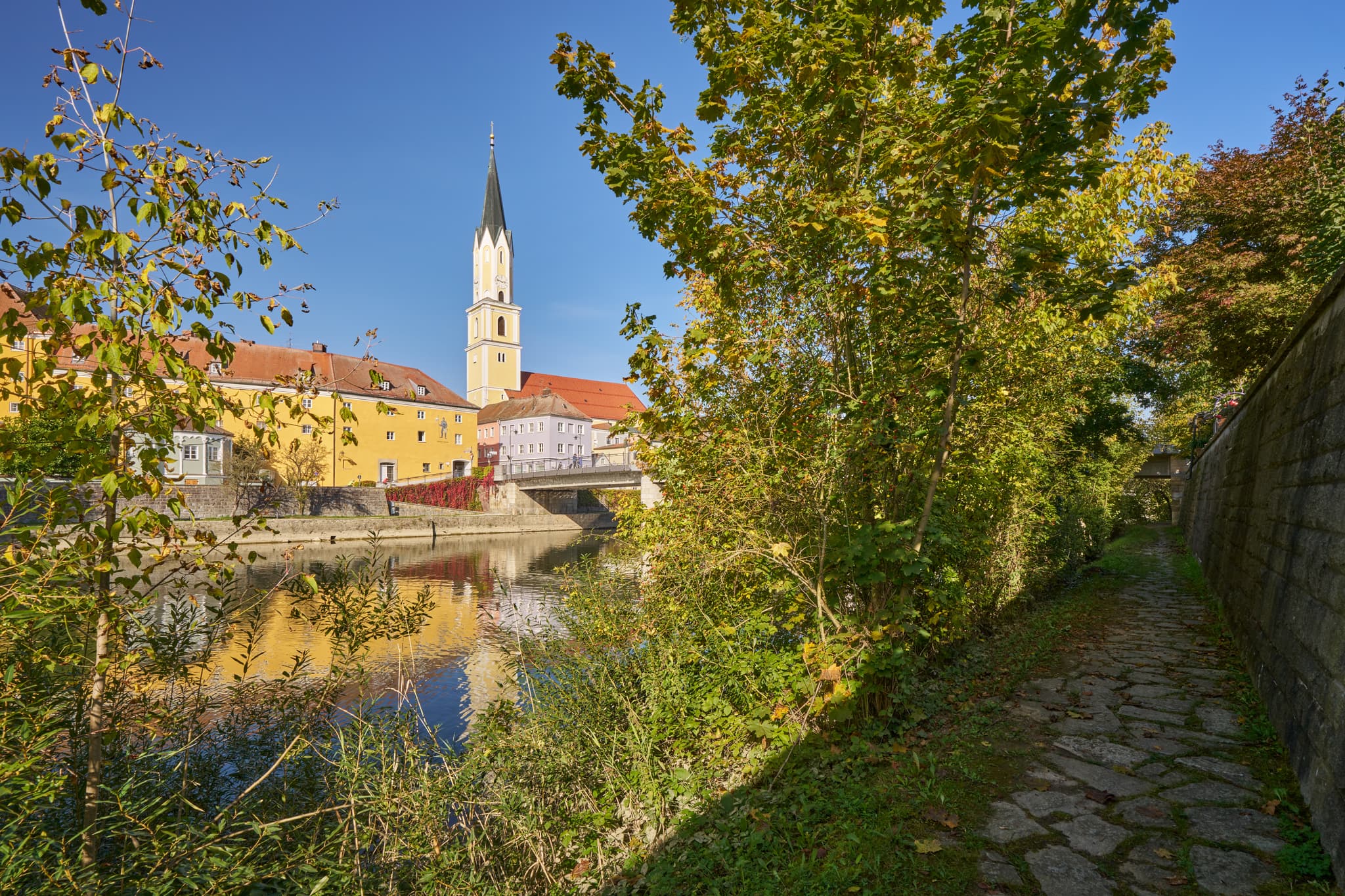 Vils Stadtansicht, Vilshofen, Passau, Niederbayern - Stadtansicht Vilshofen an der Vils, Landkreis Passau, Niederbayern. Historische Gebäude, Kirchturm und Brücke spiegeln sich im Fluss. Donau-Wald, Deutschland.