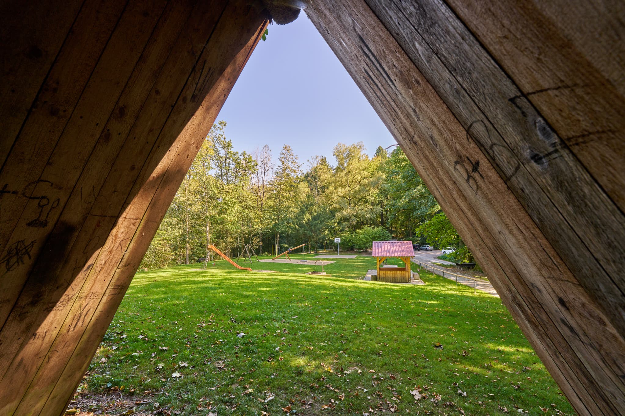 Waldwunderwelt, Bad Griesbach, Landkreis Passau - Spielplatz in Bad Griesbach, Passau, Niederbayern. Blick durch Holzkonstruktion auf Grünfläche mit Spielgeräten. Niederbayern, Bayern, Deutschland.