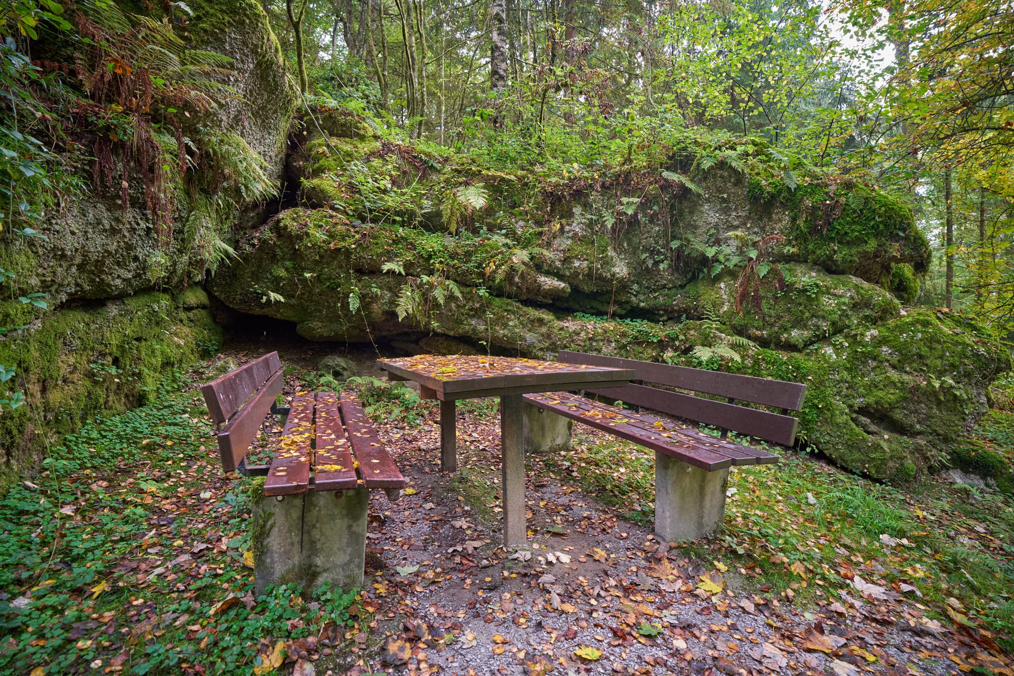 Waldwunderwelt, Bad Griesbach, Landkreis Passau - Picknicktisch und Bänke vor felsiger Felsformation im Wald. Bad Griesbach, Landkreis Passau, Niederbayern, Bayerischer Wald, Deutschland.