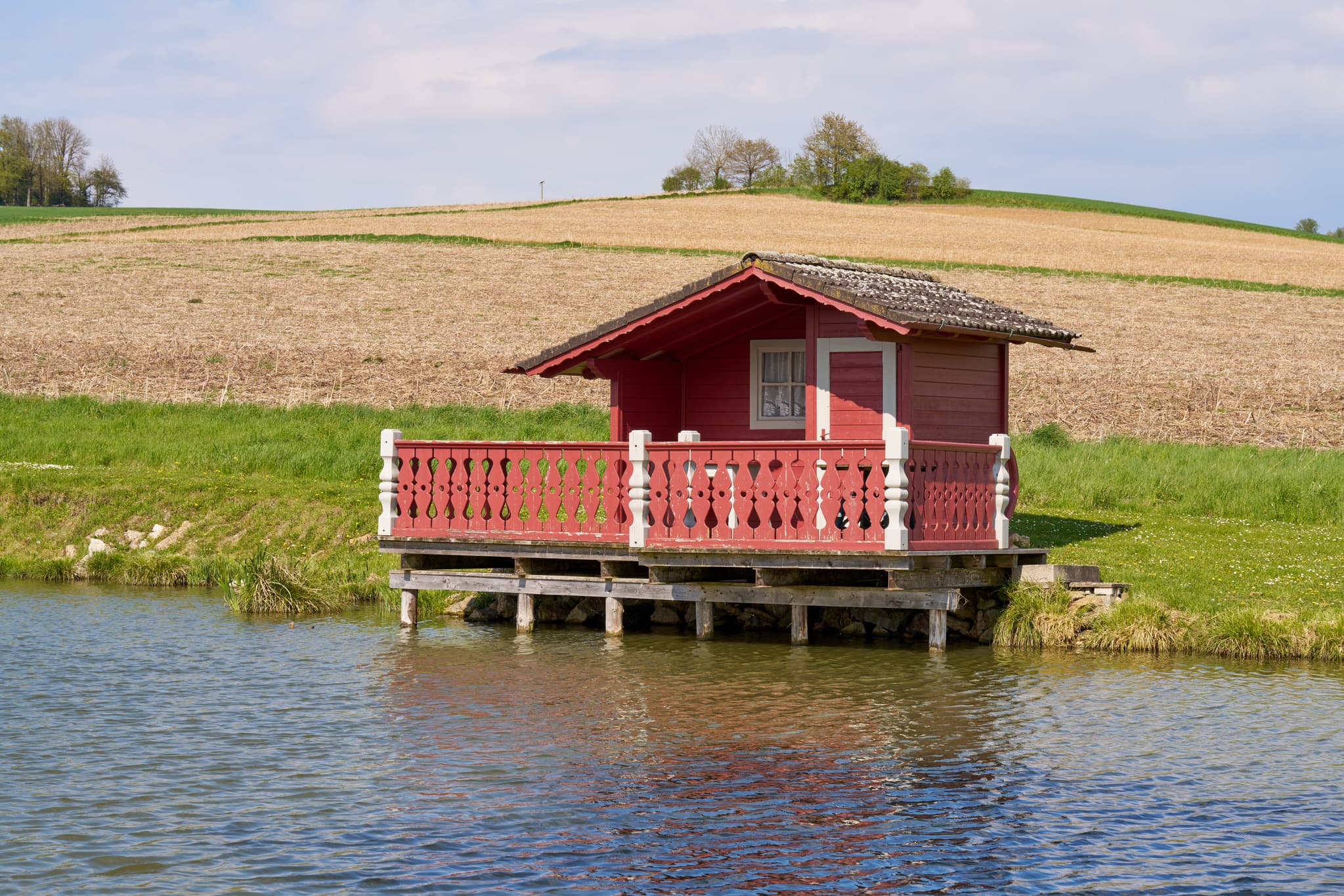 Weng Badeweiher, Bad Griesbach, Niederbayern, Bäderdreieck - Idyllisches rotes Fischerhäuschen am Weng Badeweiher in Bad Griesbach im Landkreis Passau, Niederbayern, Deutschland. Malerische Landschaft im Bäderdreieck.