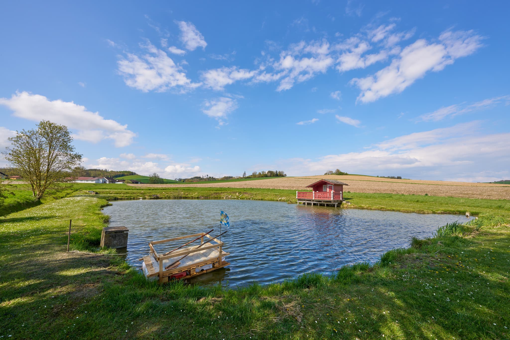 Weng Badeweiher, Bad Griesbach, Niederbayern, Bäderdreieck - Idyllisches rotes Fischerhäuschen am Weng Badeweiher in Bad Griesbach im Landkreis Passau, Niederbayern, Deutschland. Malerische Landschaft im Bäderdreieck.