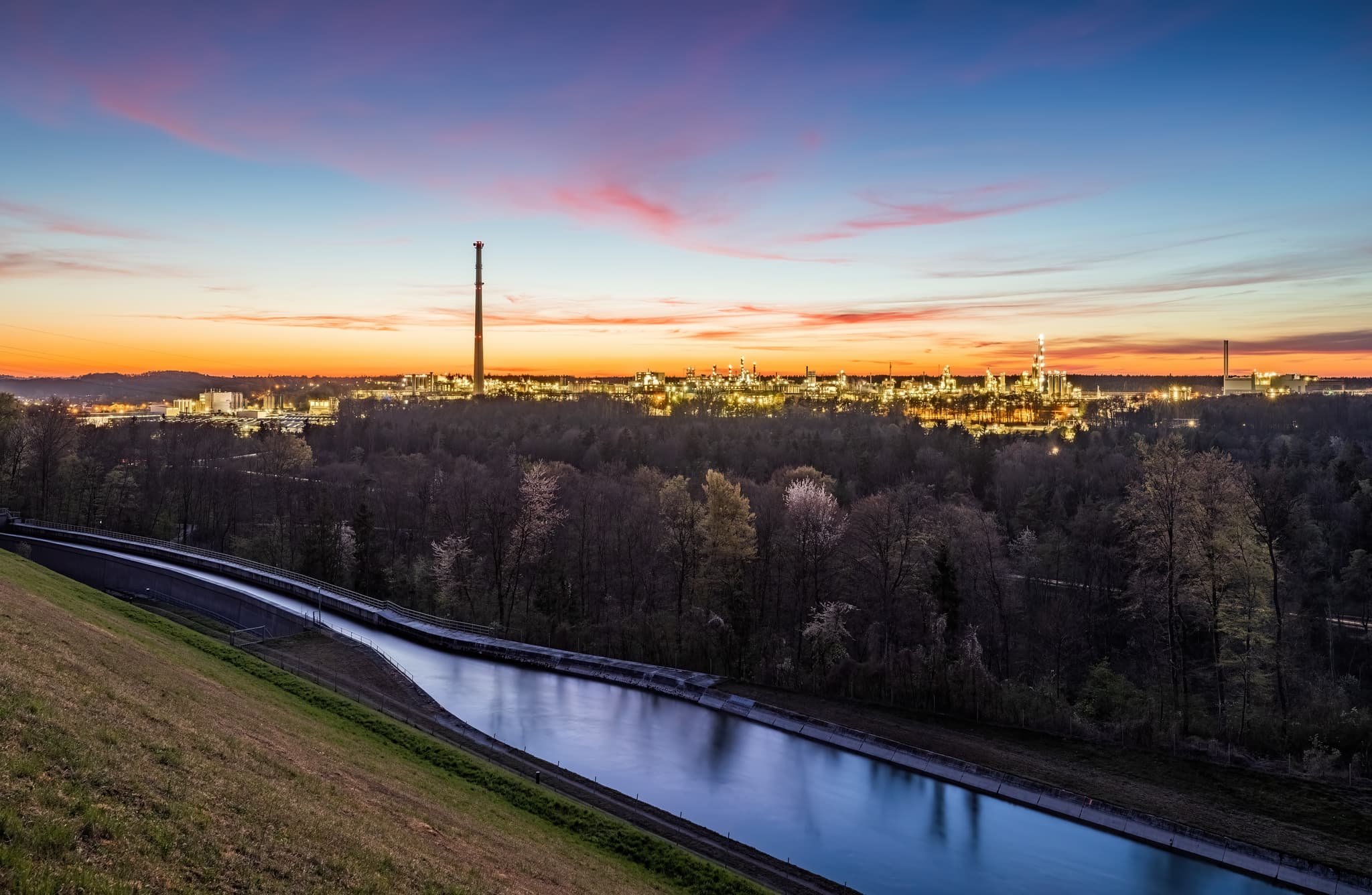 Werk Gendorf Alzkanal, Burgkirchen, Altötting, Oberbayern - Industriepark Werk Gendorf mit Alzkanal, Burgkirchen, Landkreis Altötting, Oberbayern. Beleuchtete Anlage im Abendlicht unter farbigem Himmel, Inn-Salzach.