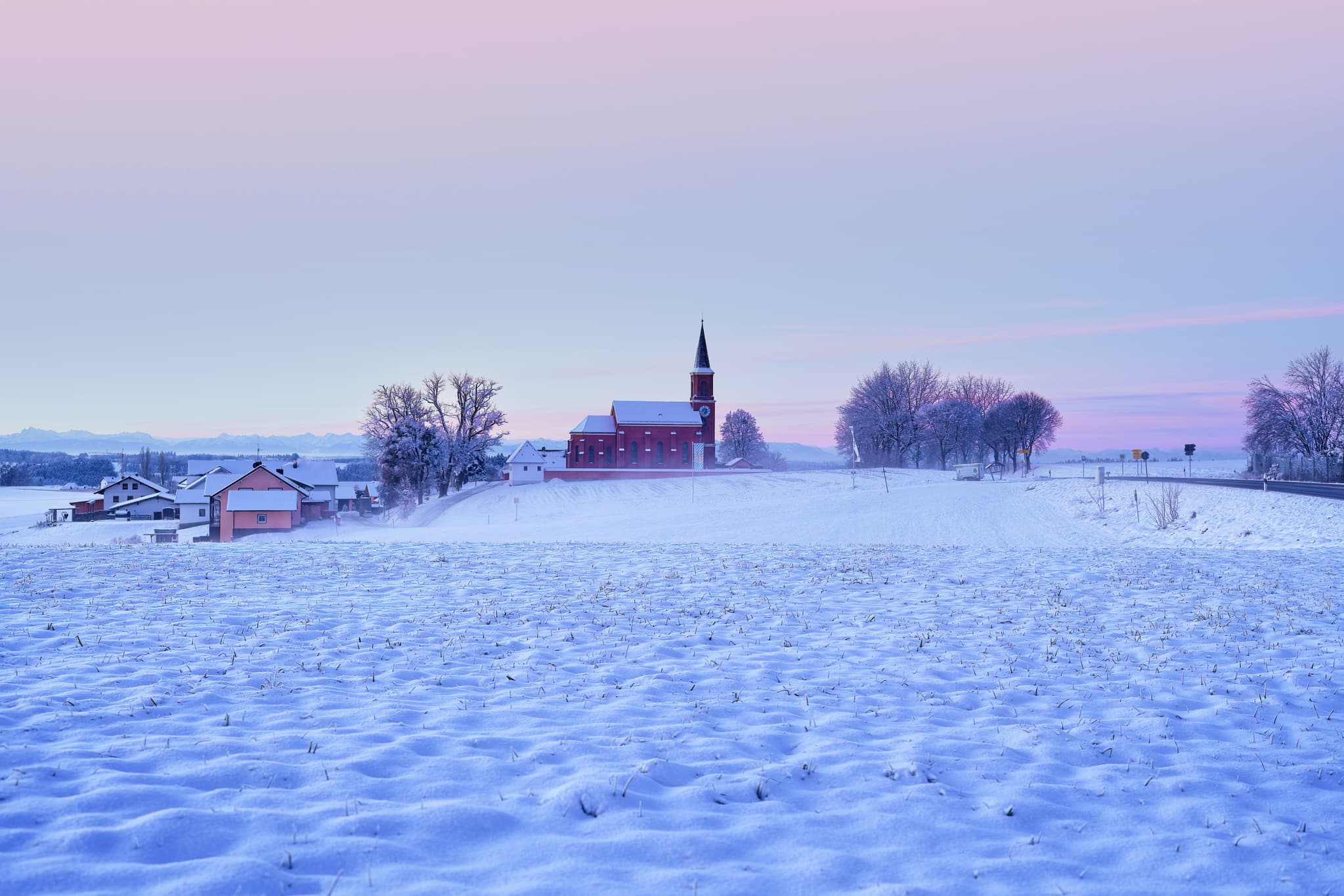 Winter in Wald bei Winhöring, Altötting, Oberbayern - Winterlandschaft bei Wald bei Winhöring, Pleiskirchen, Altötting, Oberbayern. Verschneite Felder mit Kirche und Häusern in Region Inn-Salzach, Deutschland.