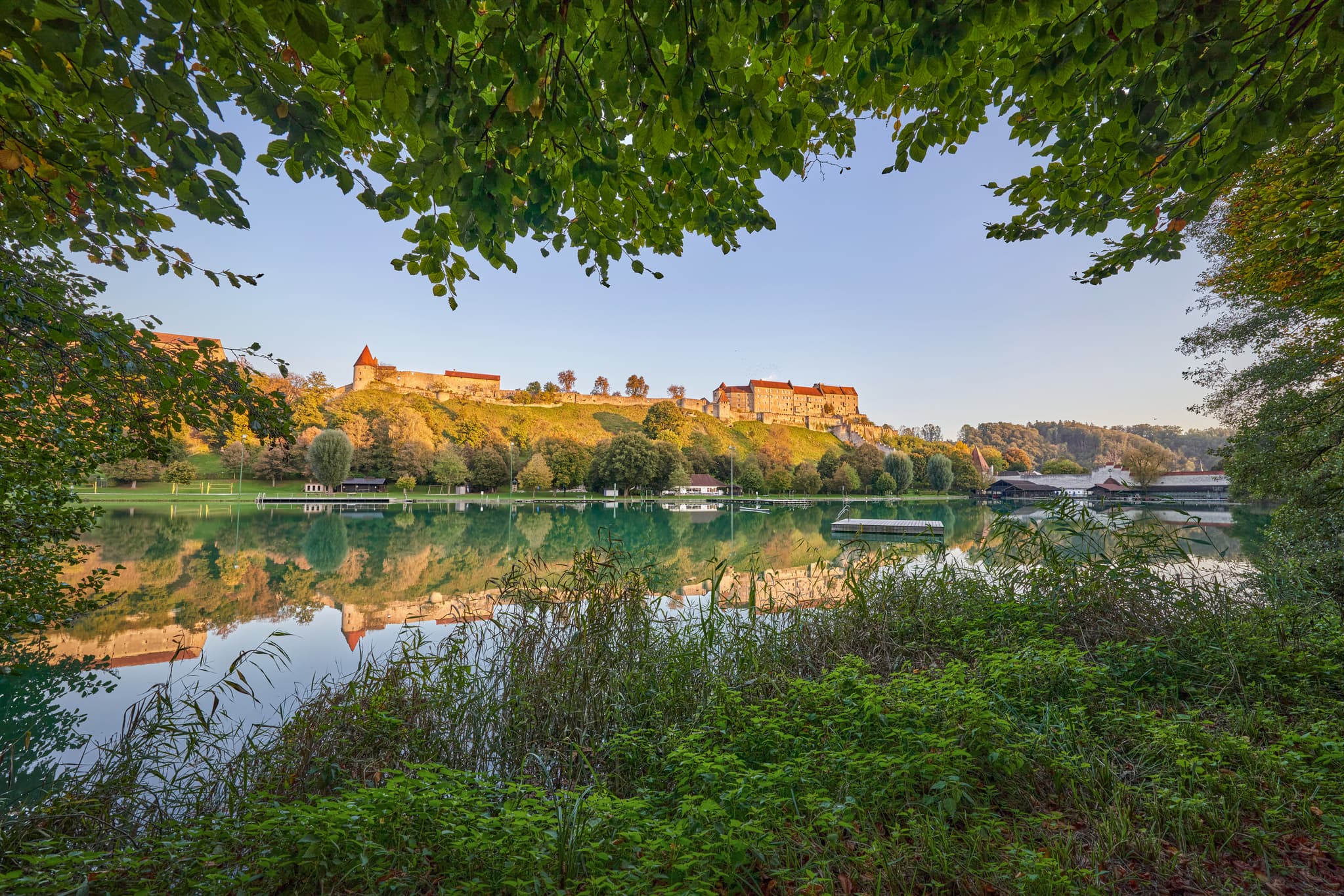 Wöhrsee mit Burg Burghausen, Landkreis Altötting, Oberbayern - Wöhrsee in Burghausen mit Burg Burghausen auf dem Hügel. Die grüne Landschaft des Landkreises Altötting, Oberbayern, Region Inn-Salzach. Spiegelung im See.