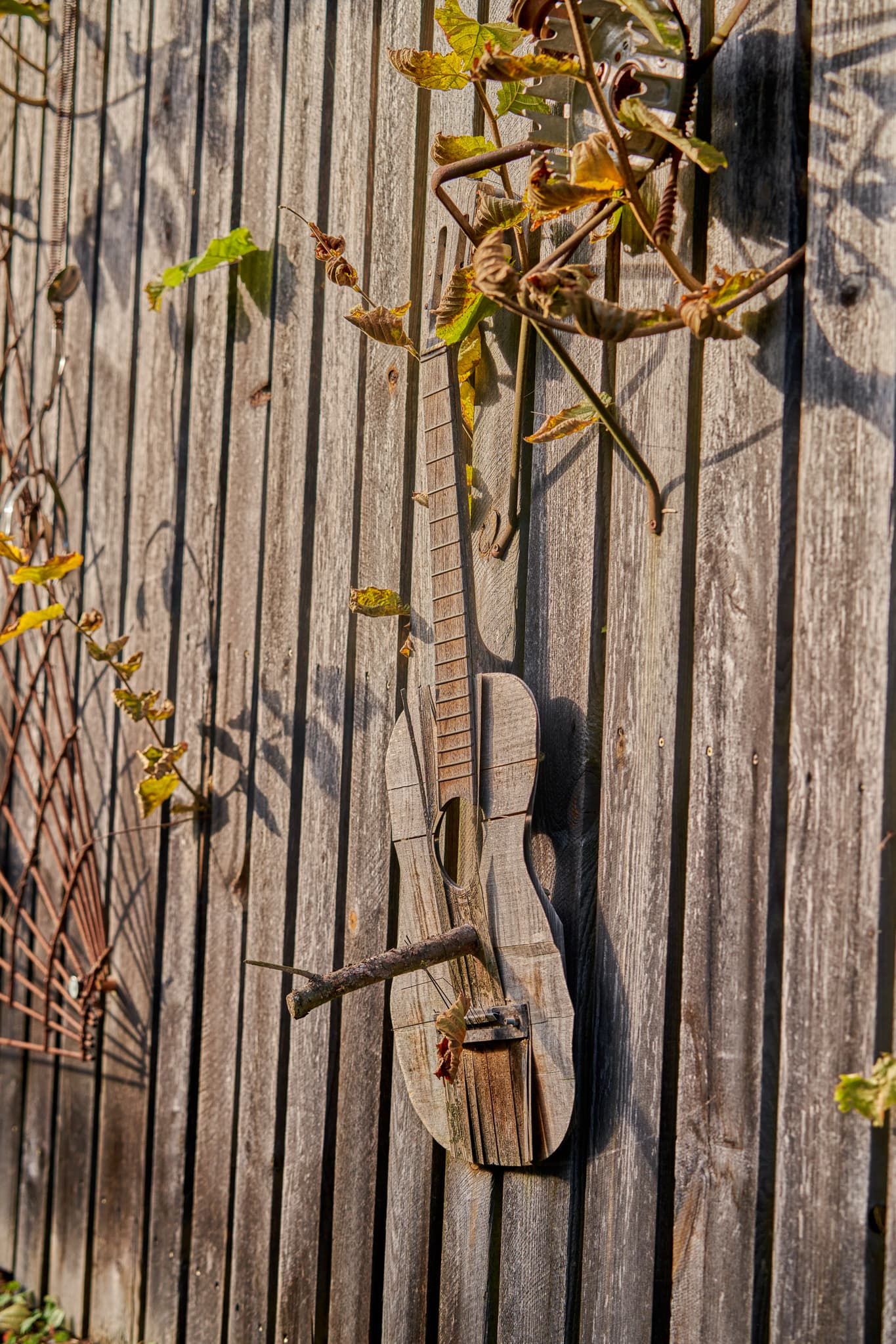 Zaun Hörniweg, Rätselweg Schönau, Rottal-Inn, Niederbayern - Eine detailreiche Aufnahme eines rustikalen Holzzauns mit einer kreativen Holzgitarre als Dekoration in Schönau, Landkreis Rottal-Inn, Niederbayern, Holzland